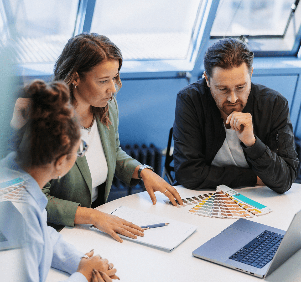 Floor Seven Mitarbeiter und Mitarbeiterinnen an einem Tisch in Zusammenarbeit